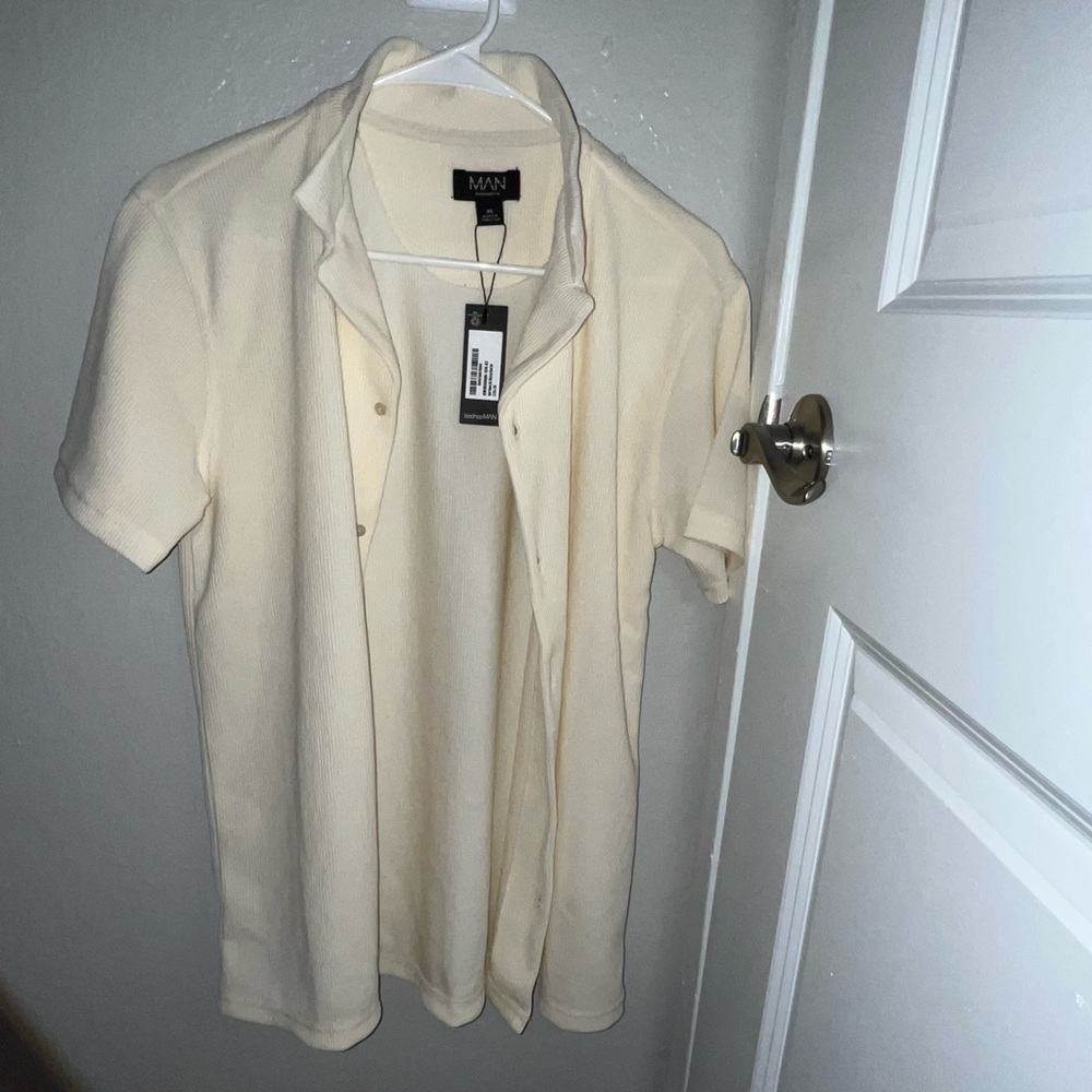 It’s a short sleeve rib shirt. XS Men’s size, cream color. Brand BooHooMAN